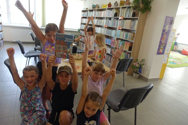 zwycięzka drużyna pozuje do zdjęcia z uśmiechami na twarzach i podniesionymi rękoma