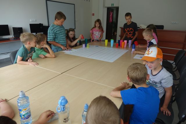 dzieci kodują przy pomocy kolorowych kubeczków