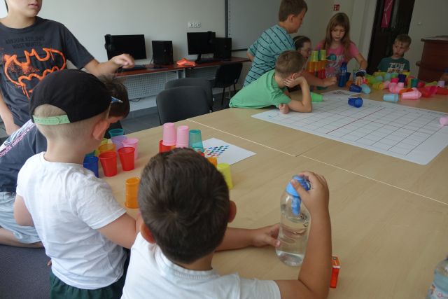 dzieci kodują przy pomocy kolorowych kubeczków