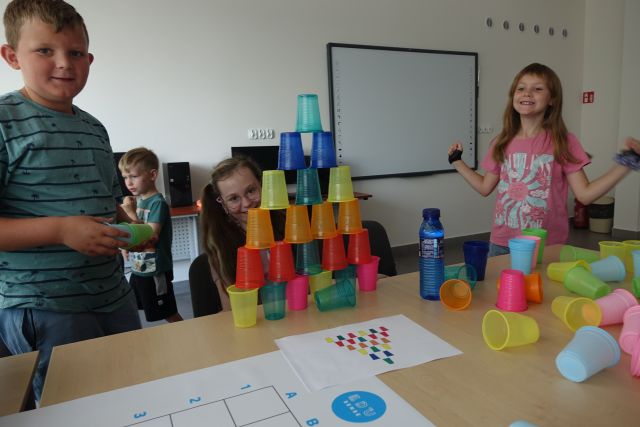 dzieci kodują przy pomocy kolorowych kubeczków