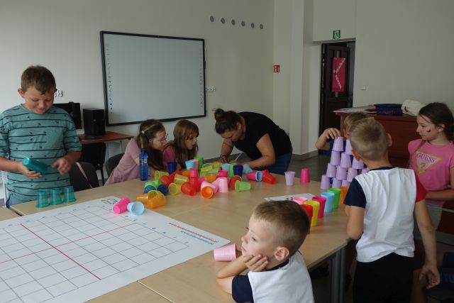 dzieci kodują przy pomocy kolorowych kubeczków