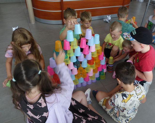 uczestnicy zajęć programują układając według kodu kolorowe kubeczki