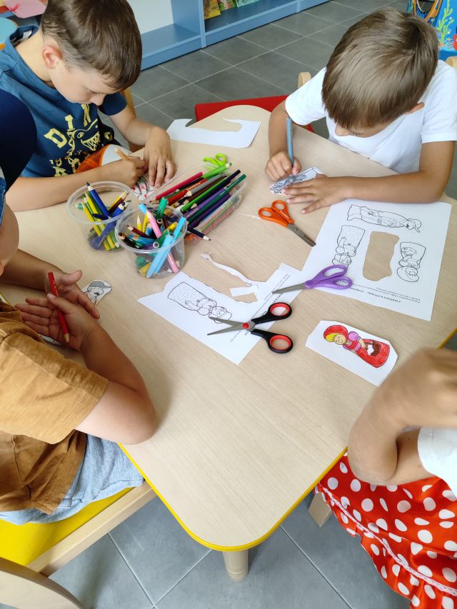 dzieci kolorują pacynki postaci z czetwonego kapturka