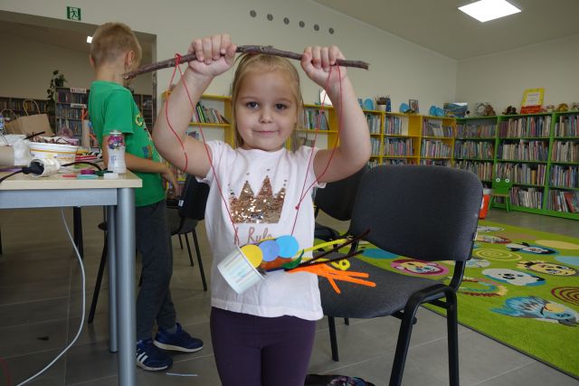 dziewczynka pokazuje wykonaną przez siebie zabawkę z materiałó recyklingowych