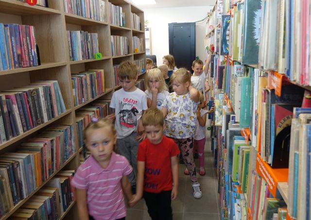 przedszkolaki między regałami z książkami