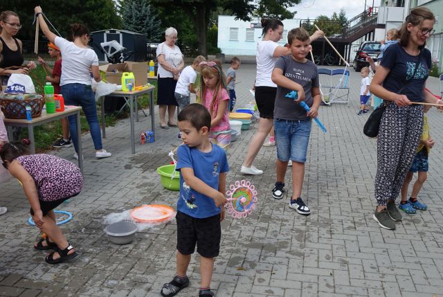 dzieci na placu przed biblioteką robią bańki mydlane