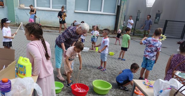 dzieci i soby dorosłe robią bańki mydlane