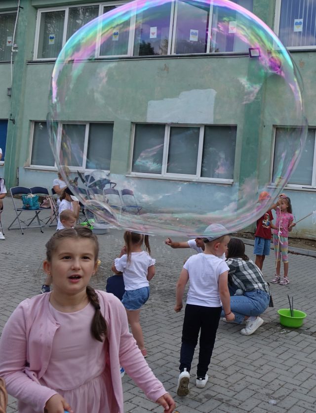 dziewczynka zrobiła ogromną bańkę mydlaną