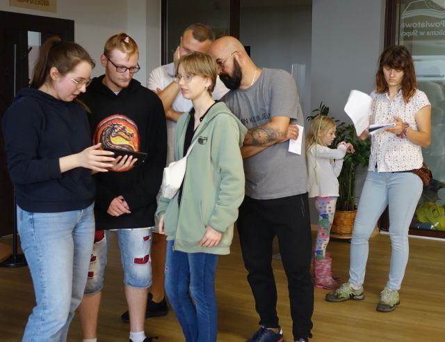 część uczestników gra sterują robotami przy użyciu tabletów, pozostali stoją i patrzą