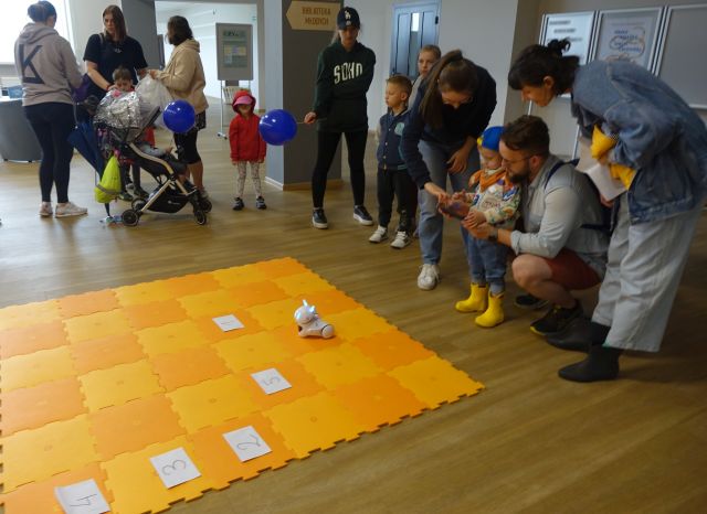 część uczestników gra sterują robotami przy użyciu tabletów, pozostali stoją i patrzą