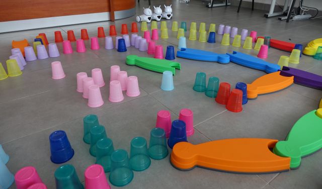 kolorowe kubeczki ułożone na podłodze w taki sposób że tworzą tor przeszkód dla robotó photon