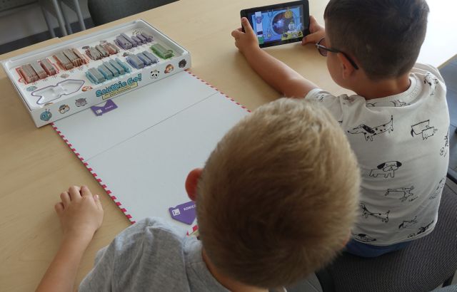 dwóch chłopców gra na tablecie