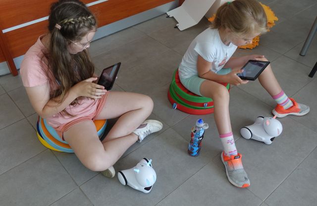 dwie dziewczynki sterują robotami przy użyciu tabletów