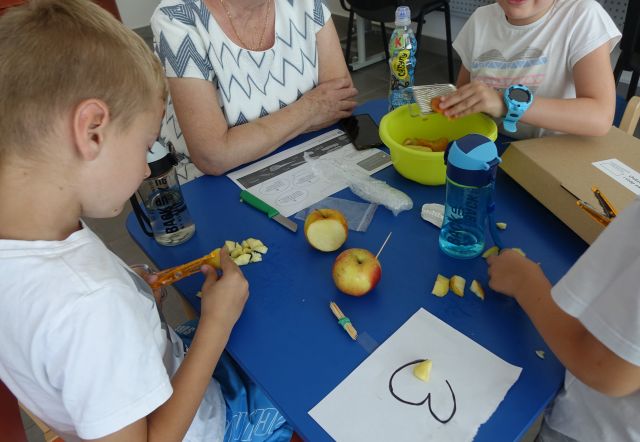 dzieci obierają jabłka