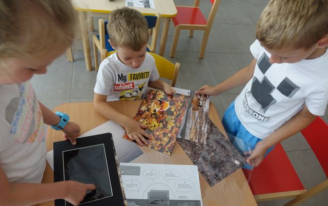 dzieci oglądają ilustracje lasów