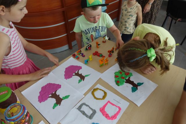 plastusie z plasteliny oraz drzewa wyklejone na kartkach z plasteliny