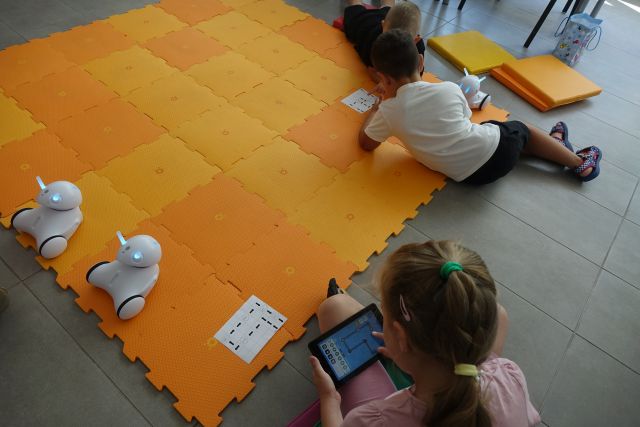 dzieci sterują robotami przy użuciu tabletów