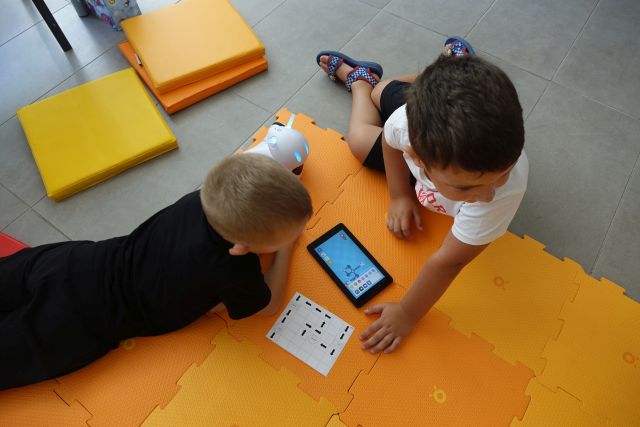 dwóch chłopców aprowadza hasłą zapisane na kartce do tabletu