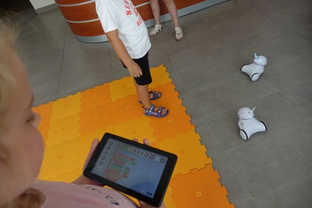 cgłopcy sterują robotami przy użyciu tabletów
