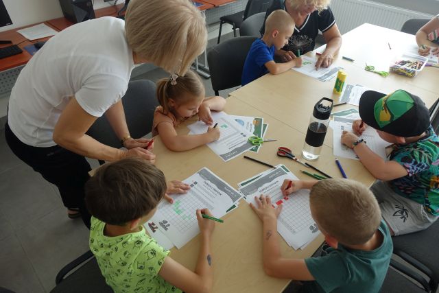 dzieci malują krzyżówki na kartkach