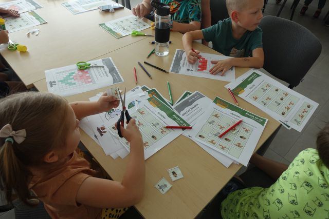 dzieci rozwiązują zagadki na kartkach