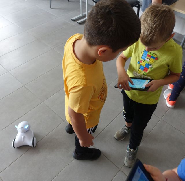 dzieci sterują robotami przy pomocy tabletów
