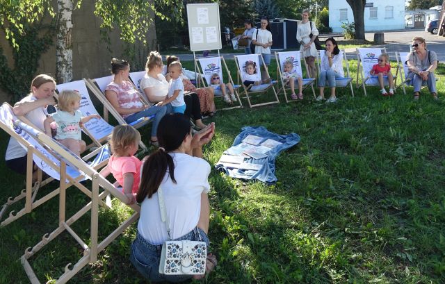 dzieci i opiekunowie siedzą na leżakach