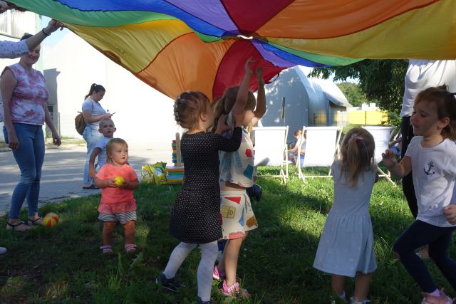 dzieci bawią się pod kolorową chustą