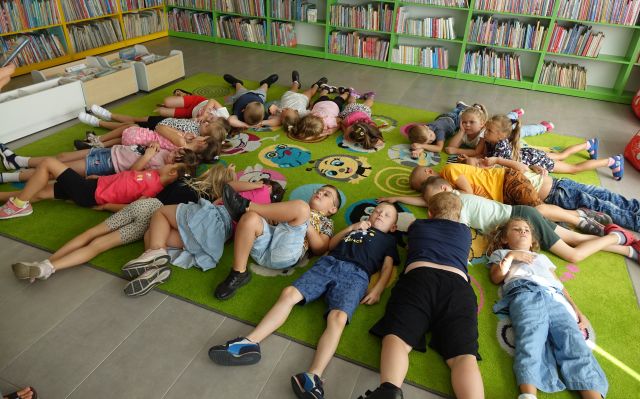 dzieci leżą na kolorowym dywanie