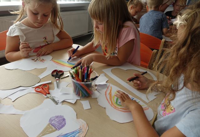 dzieci przy stoliku malują na kartkach