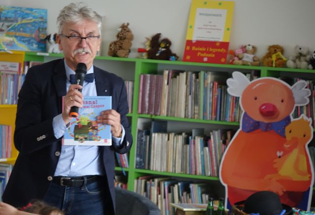 pisarz pokazuje dzieliom książkę