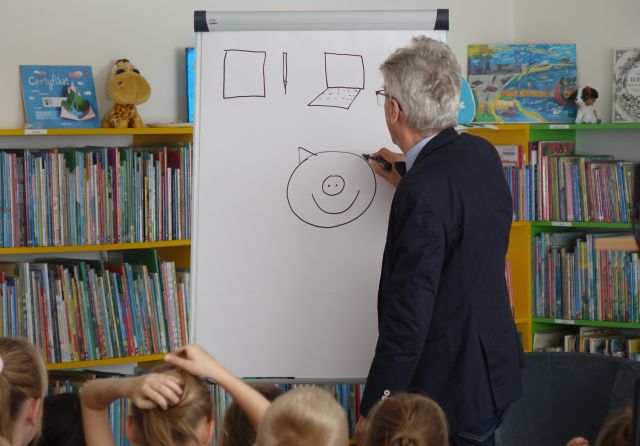 pisarz rysuje na kartkach papieru 