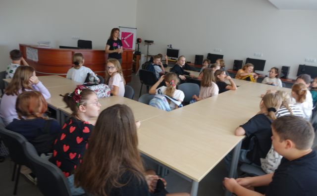 czwartoklasiści w sali komputerowej siedzą przy stołach