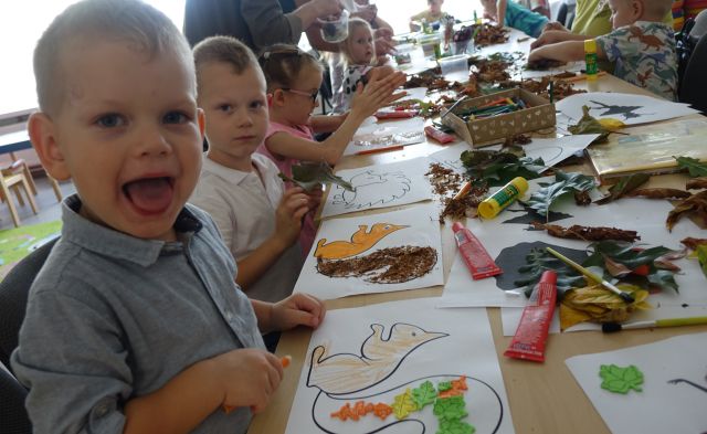 dzieci wyklejają z liści zwierzątka