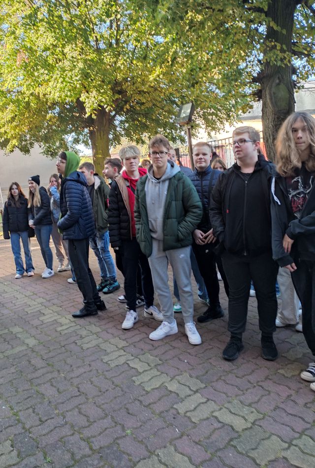 młodzież czyta tablice na kościele