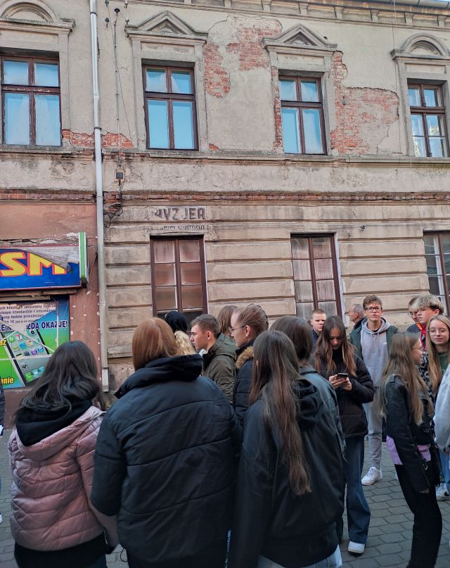 młodzież stoi przed budynkiem dawnego szewca żydowskiego