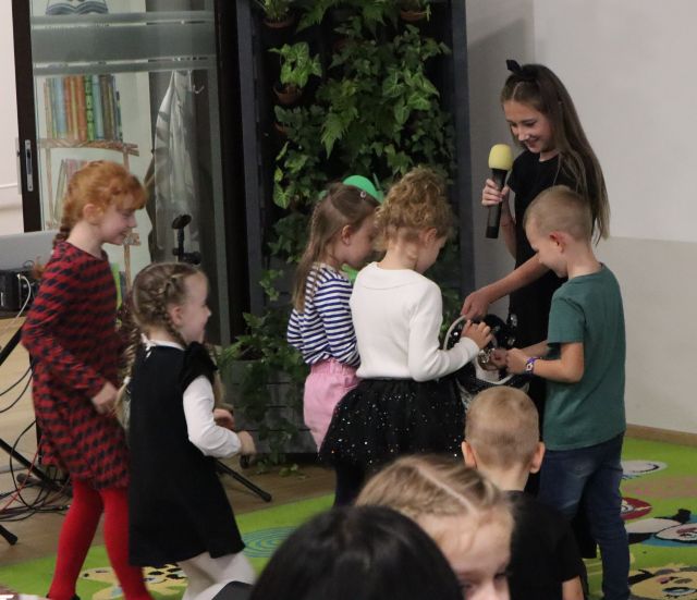 dziewczyna przebrana za kota częstuje dzieci cukierkami