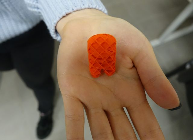 pomarańczowa figurka na dłoni