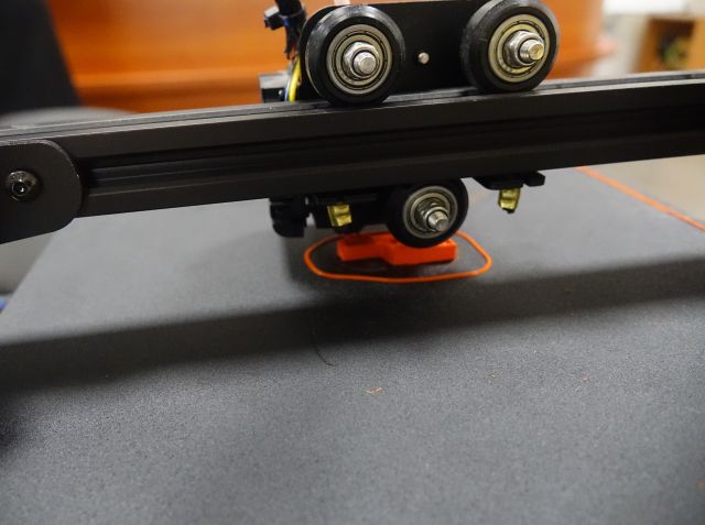 drukarka 3D drukuje pomarańczowe auto