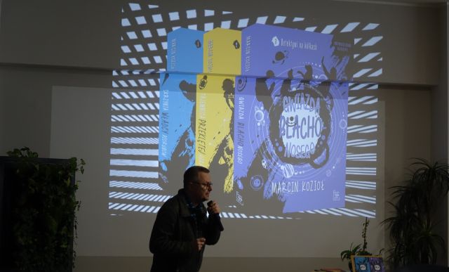 pisarz pokazuje prezentację z książkami