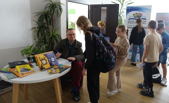 młodzież stoi w kolejce po autografy od pisarza