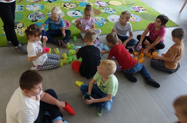 dzieci układają kolorowe kubeczki