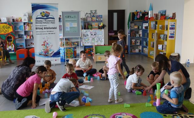 dzieci ukłądają wieże z kolorowych kubeczków