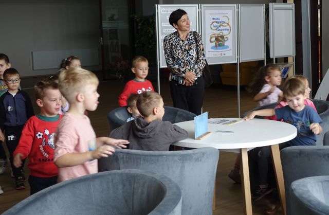 przedszkolaki siedzą na fotelach w czytelni biblioteki