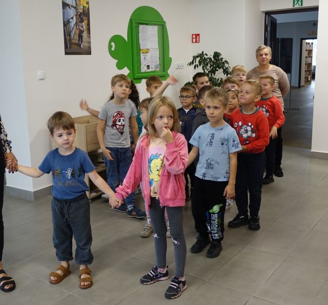 przedszkolaki zwiedzają pomieszczenie biblioteczne