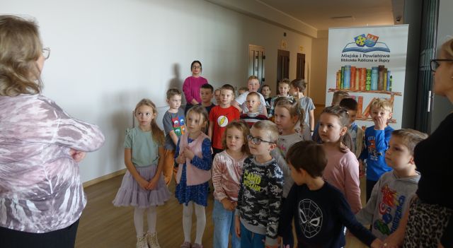 przedszkolaki i nauczycielki stoją w holu biblioteki