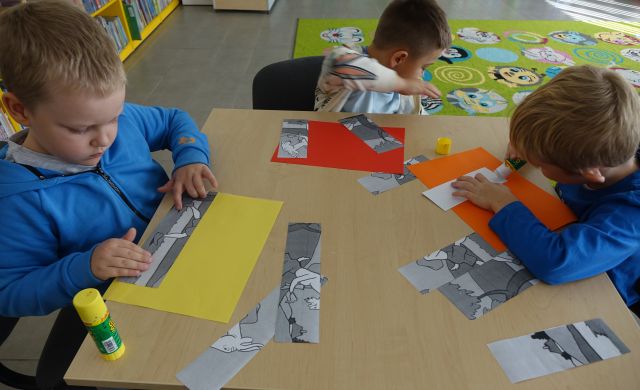 dzieci układają puzle z pociętych ilustracji z bajek