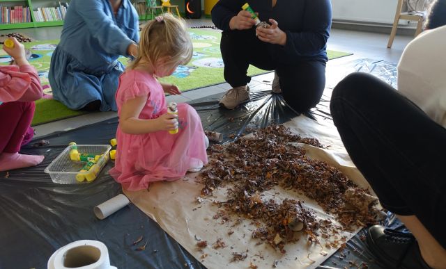 mali i starsi uczestnict klubu malucha ulkładają suszone liście