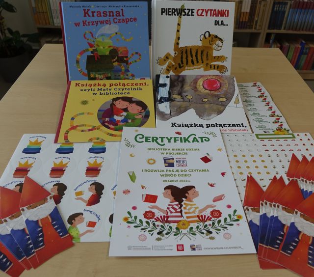 książki, zakłądki, certyfikat i naklejki rozłożone na stole