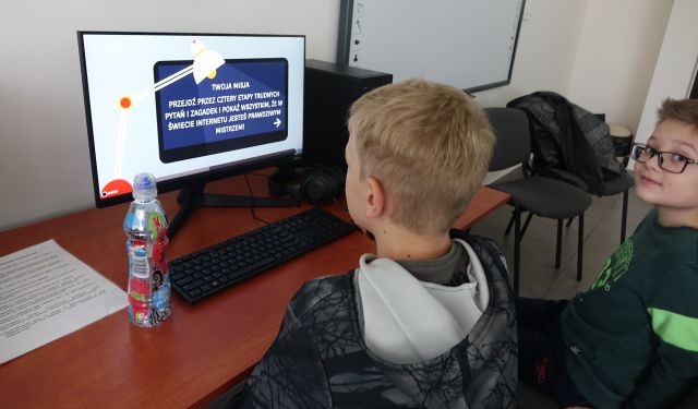 chłopcy rozwiązują zadanie na komputerze